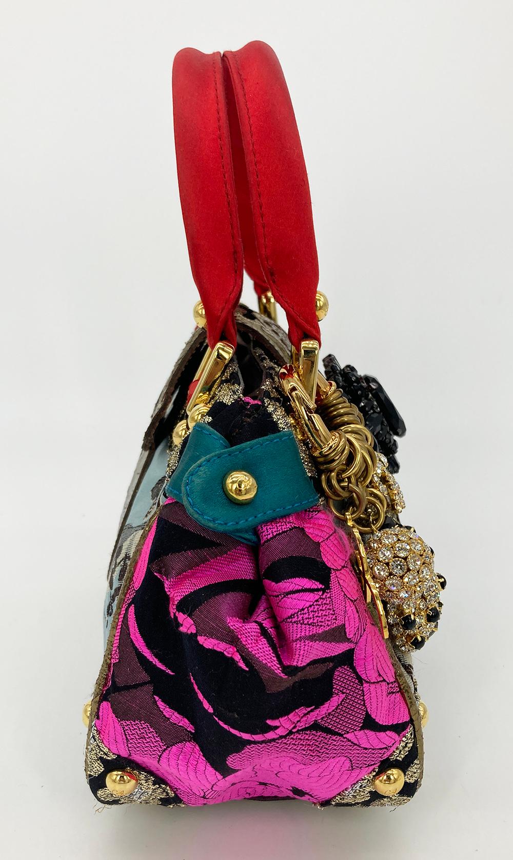 Christian Lacroix Embroidered Silk Crystal Charm Embellished Handbag in good condition. multi color silk exterior with various brocade fabrics, metallic embroidery, bronze leather piped edges, red silk handles, gold hardware and crystal covered