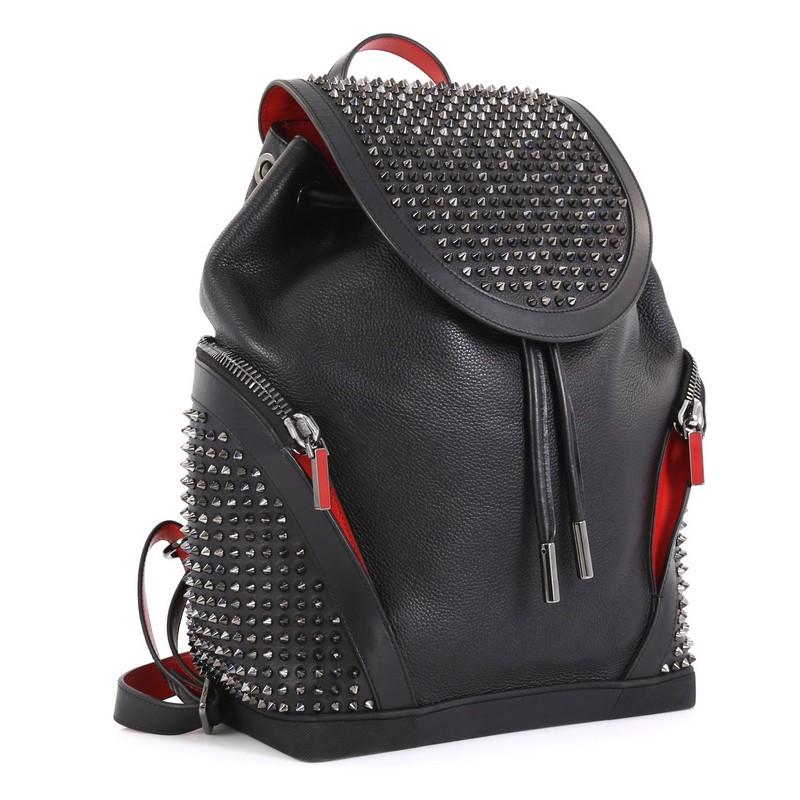 This Christian Louboutin Explorafunk Backpack Spiked Leather, crafted in black spiked leather, features flat leather top handle, adjustable leather shoulder straps, side zip pockets, frontal flap, and gunmetal-tone hardware. Its drawstring closure