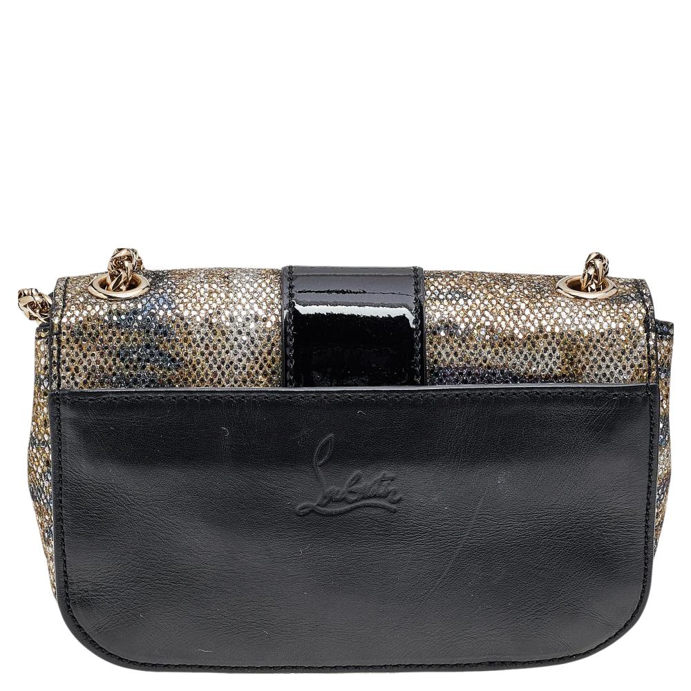 Designed by the House of Christian Louboutin, this Sweet Charity crossbody bag is a total delight for the eye! It is made from gold-black glitter and leather on the exterior, with a gold-toned accent decorating the front. It comes with a