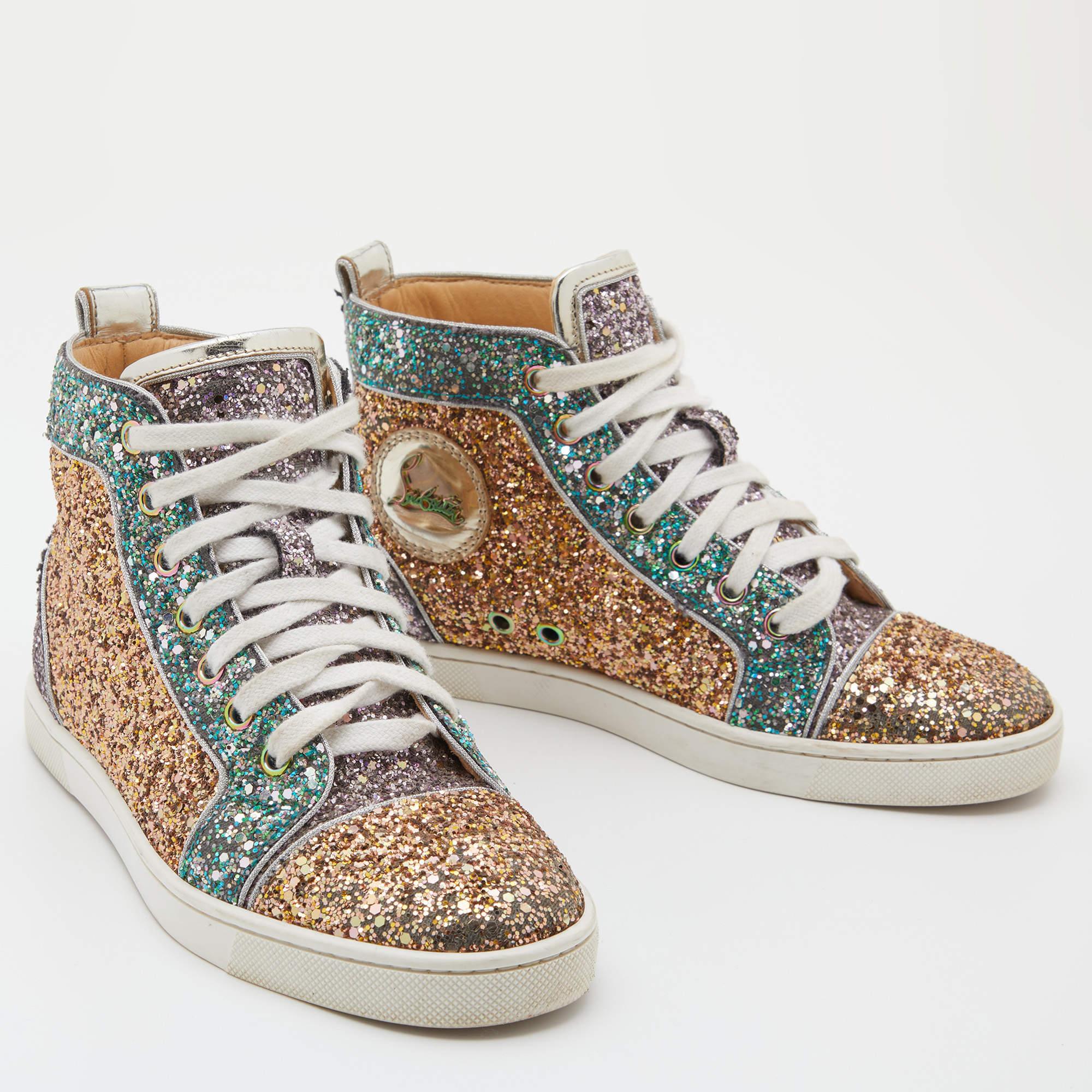 Pull off a stylish look with class in this pair of Bip Bip sneakers from Christian Louboutin. They feature a shimmery glitter body sculpted in a high-top silhouette. The sparkly sneakers have lace-up fronts, round toes, and the iconic red soles.


