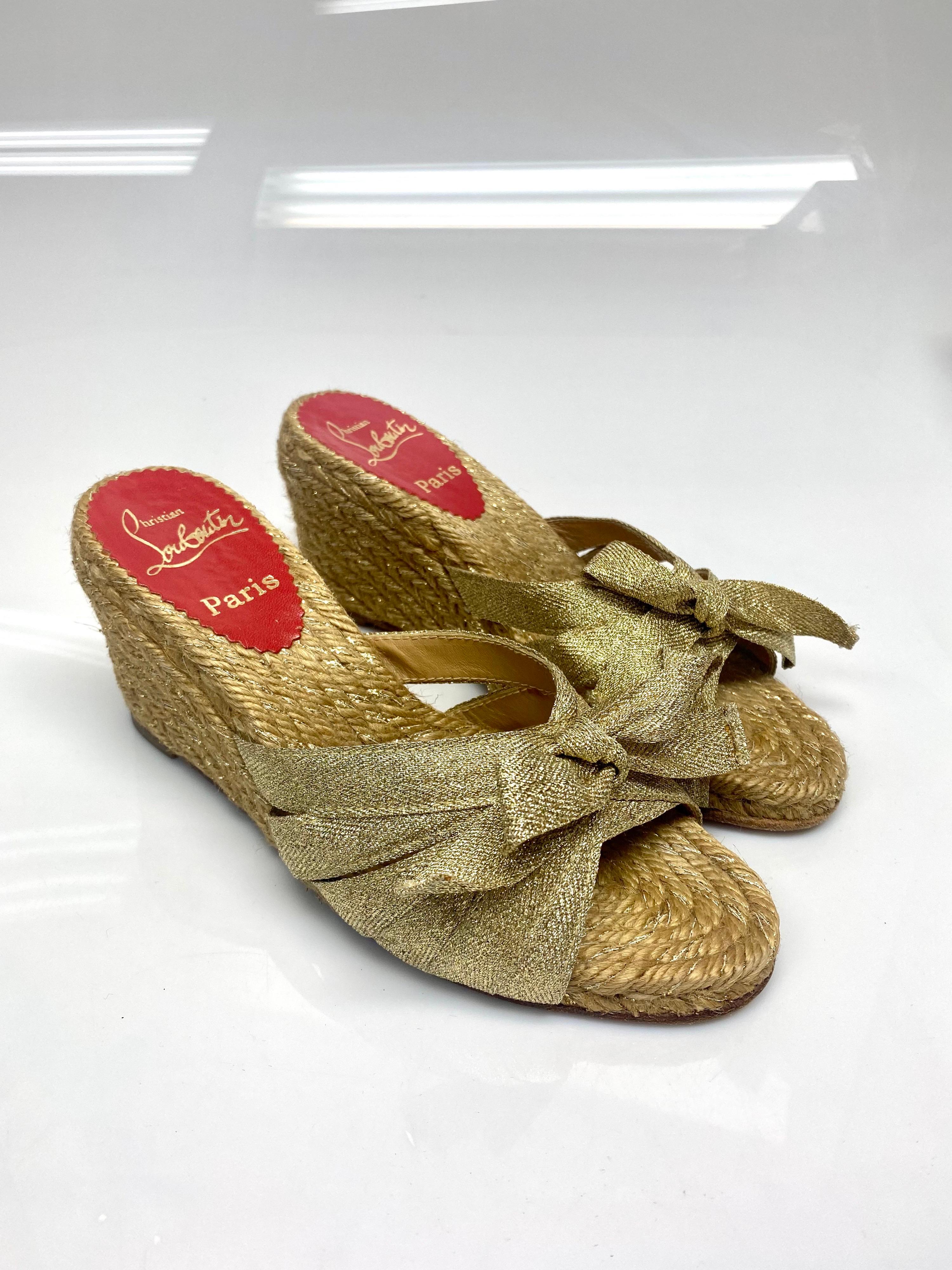 Christian Louboutin Gold Metallic Raffia Wedge Size 35. These beautiful wedges by Christian Louboutin will add some comfort and pizzazz to your outfit. Featuring gold metallic gros grain ribbon detailing with a knot tie in the front. Item is in good