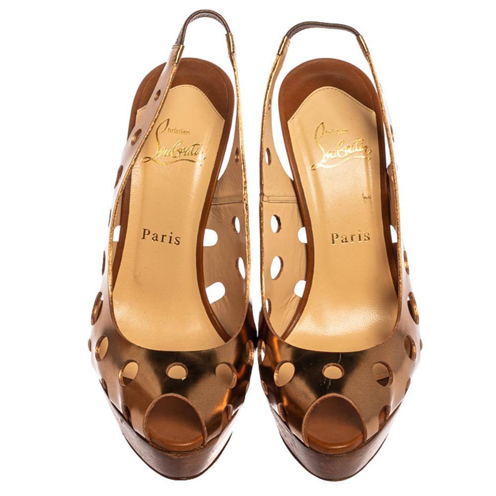 Upgrade your look by adding these gold Christian Louboutin sandals to your wardrobe. They are crafted from patent leather and designed with peep toes, platforms, and 13 cm heels. The laser-cut detailed exterior looks absolutely lovely and adds an