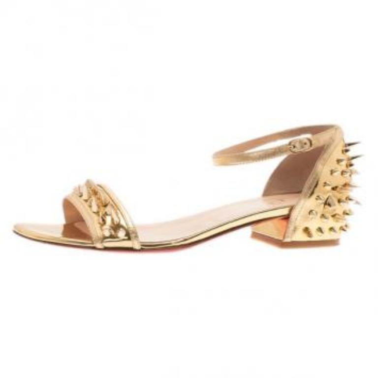 Donnez à votre tenue une touche de férocité avec cette paire de sandales Christian Louboutin. Confectionnées en cuir souple doré, elles sont conçues avec des clous et des pointes dorés sur la bride du bout du pied et les contreforts du talon.