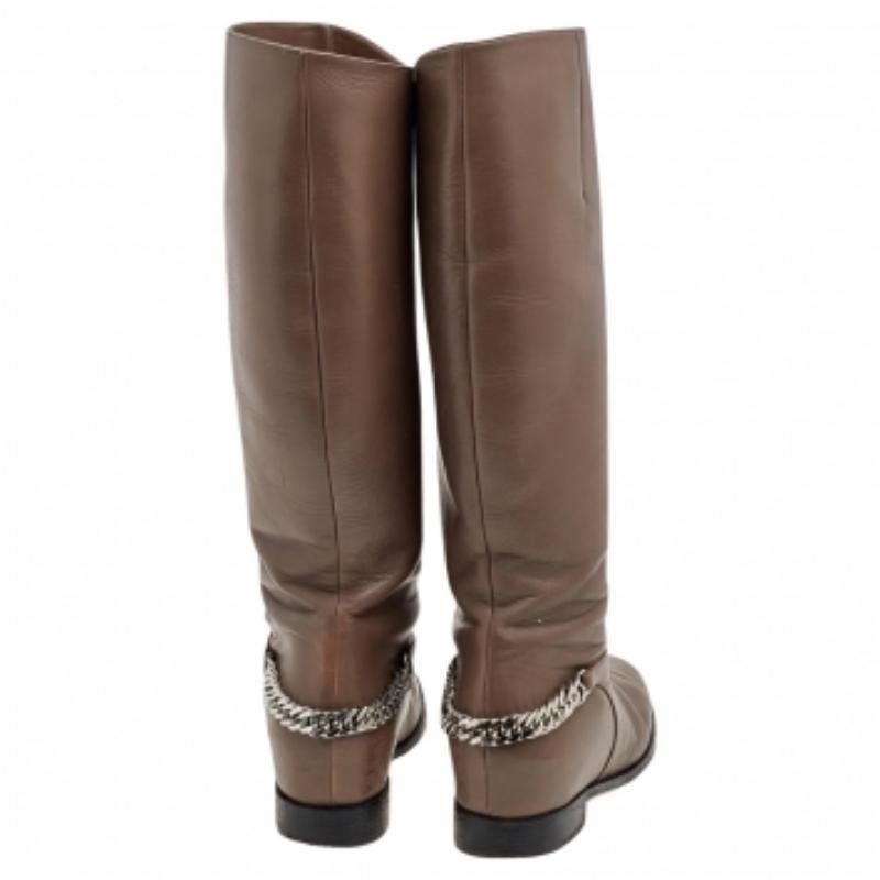 De la maison Christian Louboutin, ces bottes rendront votre style fascinant et éblouissant. Conçues en cuir gris sur l'extérieur, elles sont dotées d'une chaîne argentée et d'une longueur au genou. Ces bottes sont robustes, confortables et