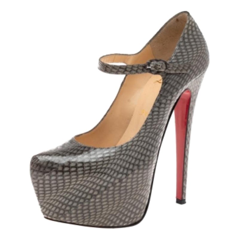 Exemplary of bold femininity, the Christian Louboutin Lady Daf pumps are a pair of statement shoes that can be flaunted well at parties and galas. Crafted in grey snakeskin leather, they are designed in a mary jane style with concealed platforms,