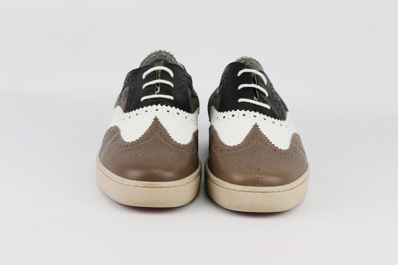 Christian Louboutin colour block leather and suede sneakers. Made from black, white, silver and brown leather with brown suede patch with perforated detail and finished with the brand’s iconic red sole. Brown, black, white and silver. Lace up