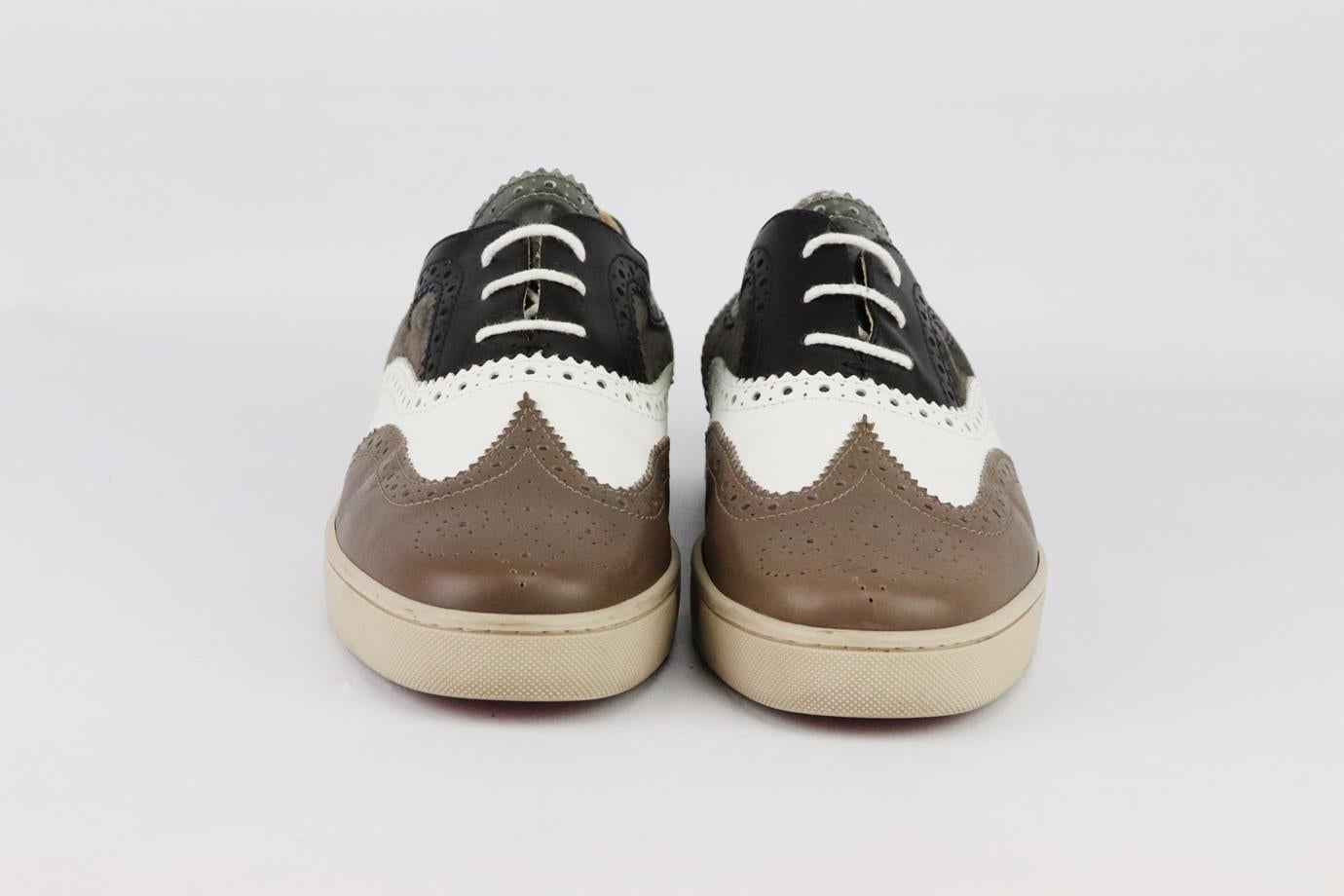 Sneakers Christian Louboutin a blocchi di colore in pelle e camoscio. Realizzate in pelle nera, bianca, argento e marrone con patch in camoscio marrone con dettagli traforati e rifinite con l'iconica suola rossa del marchio. Marrone, nero, bianco e