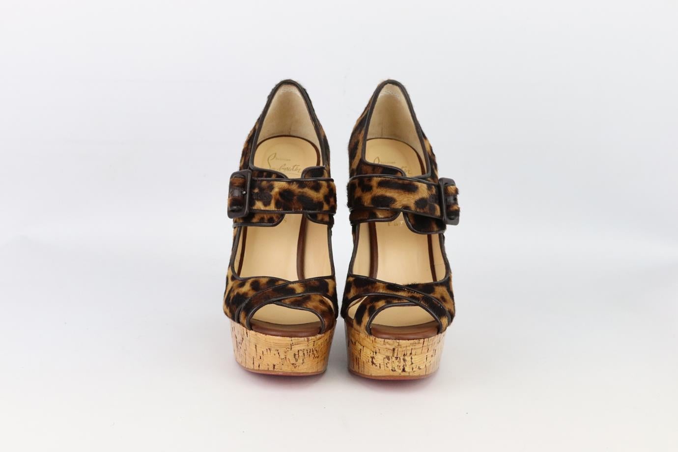 Christian Louboutin leopard print calf hair wedge sandals. Made from leopard-print calf-hair with buckle detail that are set on a cork wedge with the brand’s iconic red sole. Brown, black and tan. Buckle fastening at front. Does not come with box or