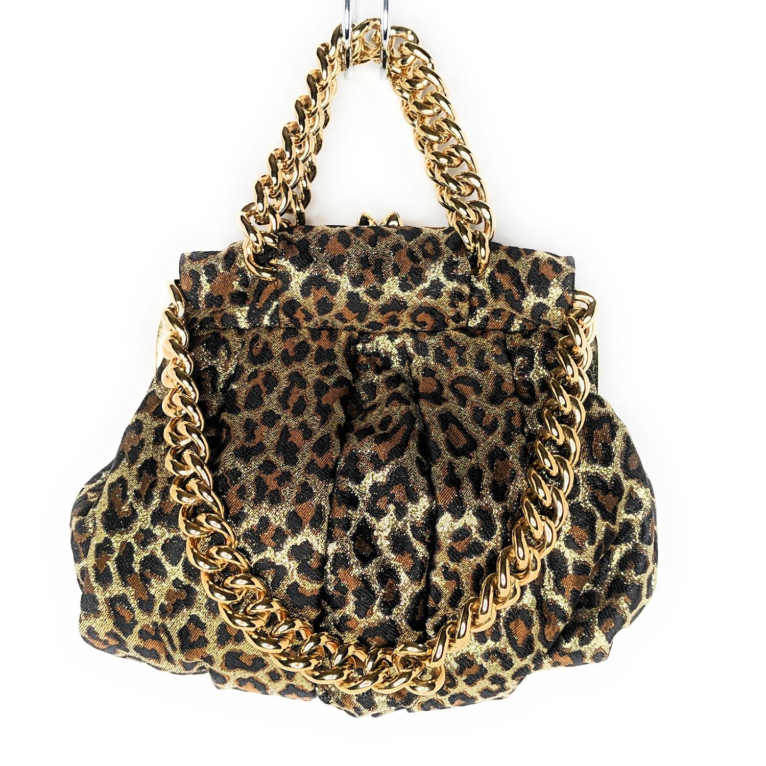 Black, brown and metallic gold Christian Louboutin leopard-patterned bag with gold-tone chains and frame top, red satin interior and molded stiletto heel hinge-lock closure. Retail price is $1,395.

Designer: Christian Louboutin
Material: Glitter