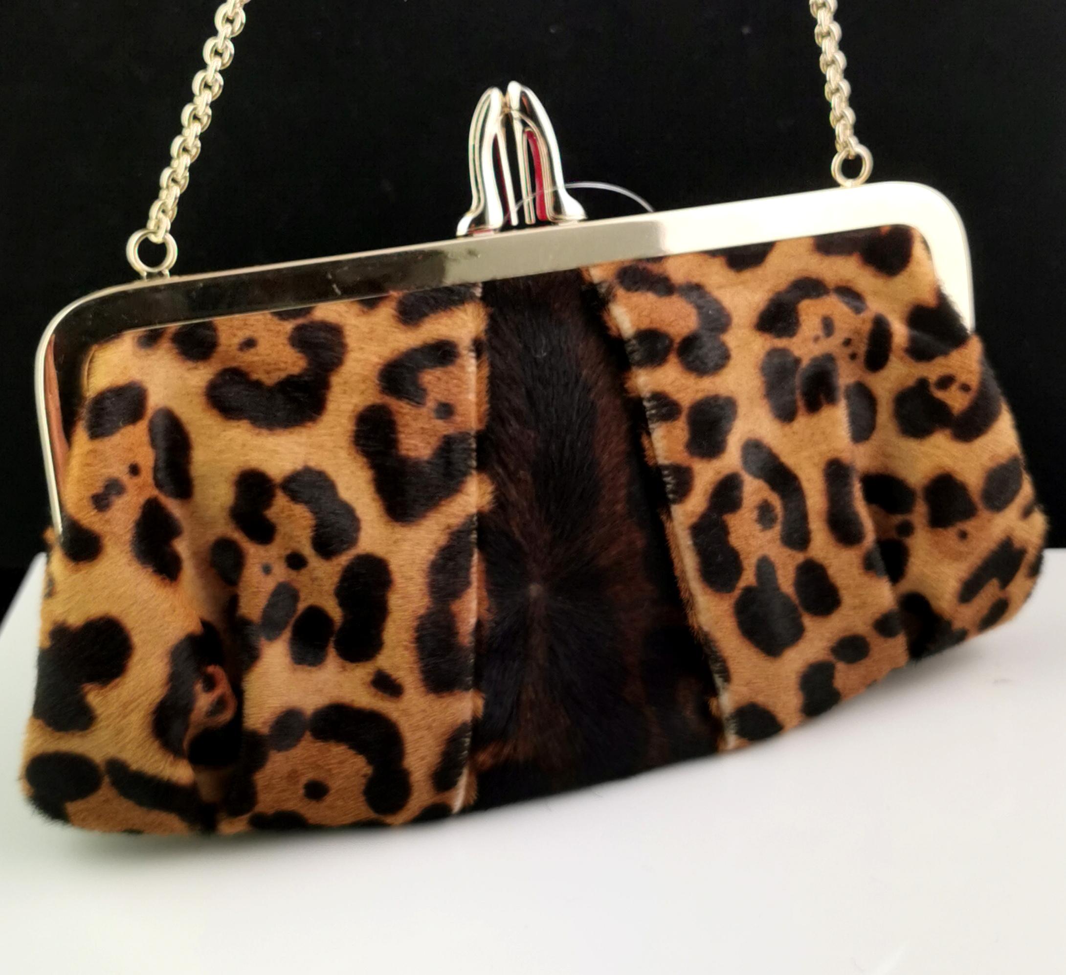 A truly stunning vintage Christian Louboutin, Loubi Lula leopard print, pony style skin clutch purse.

It has a lovely leopard print design with folded pleat corners and an iconic high heel kiss lock clasp with the memorable red soles.

The hardware
