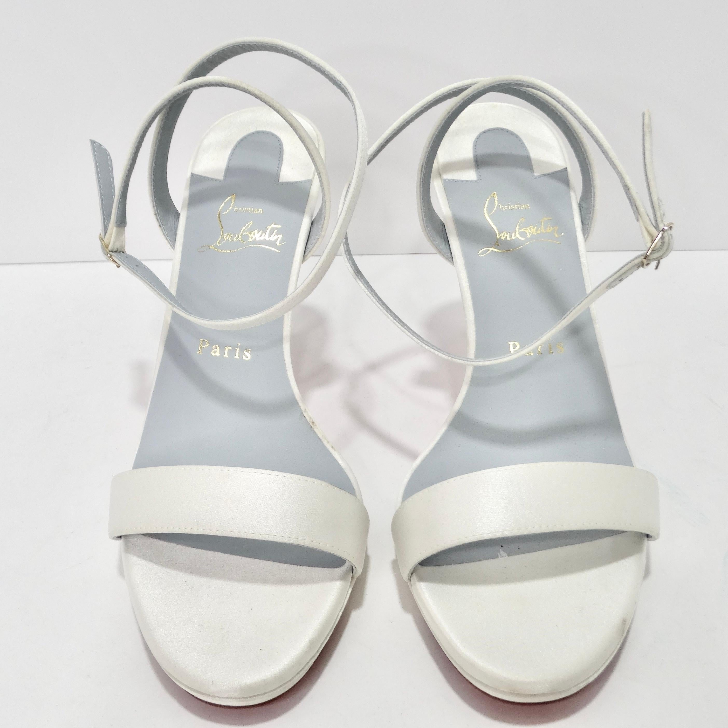 Elevate your footwear collection with the Christian Louboutin Loubi Queen Sandals, a classic and timeless strappy heel that's more than just a pair of shoes – it's a statement of enduring elegance and style. Crafted in a lustrous white satin, these