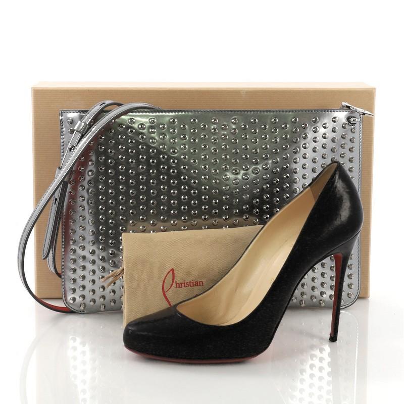 This Christian Louboutin Loubiclutch Spiked Leather, crafted from silver spiked leather, features a removable strap and silver-tone hardware. Its zip closure opens to a red fabric interior with slip pocket. **Note: Shoe photographed is used as a