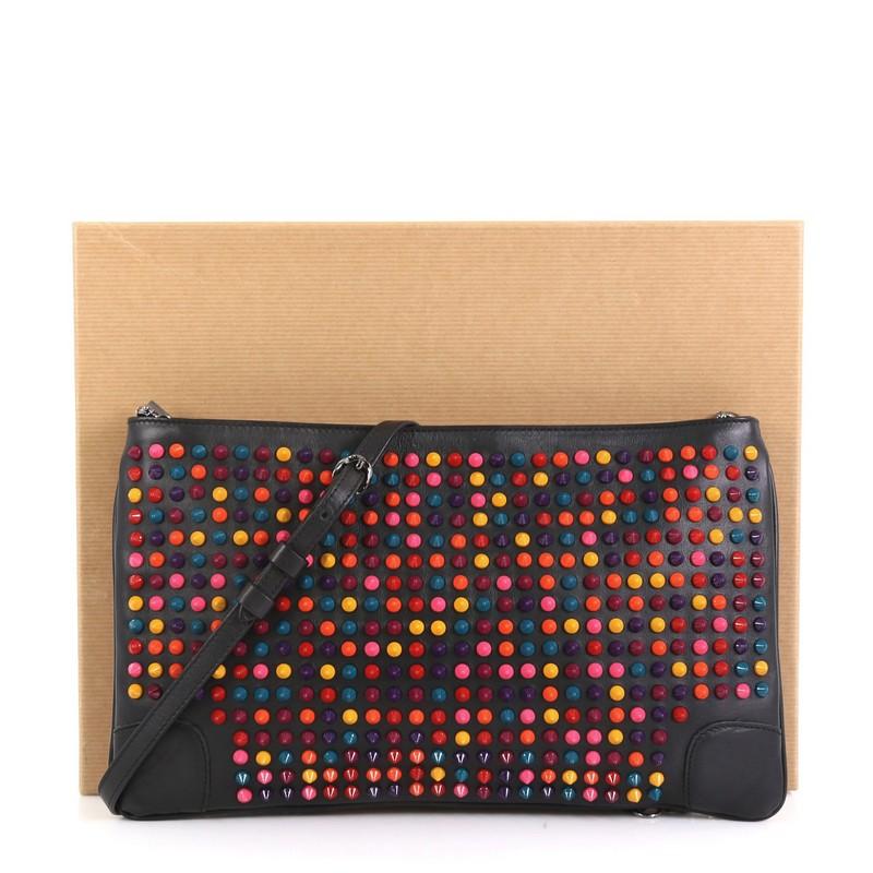 This Christian Louboutin Loubiposh Clutch Spiked Leather, crafted from black multicolor spiked leather, features a removable chain and leather shoulder strap, red enamel Louboutin logo zipper pull, and gunmetal-tone hardware. Its zip closure opens
