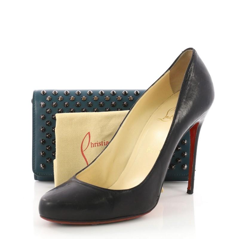 This Christian Louboutin Macaron Wristlet Spiked Leather, crafted in teal spiked leather, features multiple studs, hand strap, and silver-tone hardware. It opens to a red leather interior with multiple card slots and zip pocket. **Note: Shoe