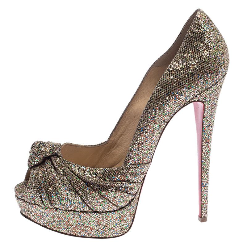 How gorgeous are these pumps from Christian Louboutin! They've been beautifully covered in glitter fabric and styled in a gathered knot on the uppers. These pumps carry peep-toes, platforms with 15.5 cm heels, and the signature red soles. Let this