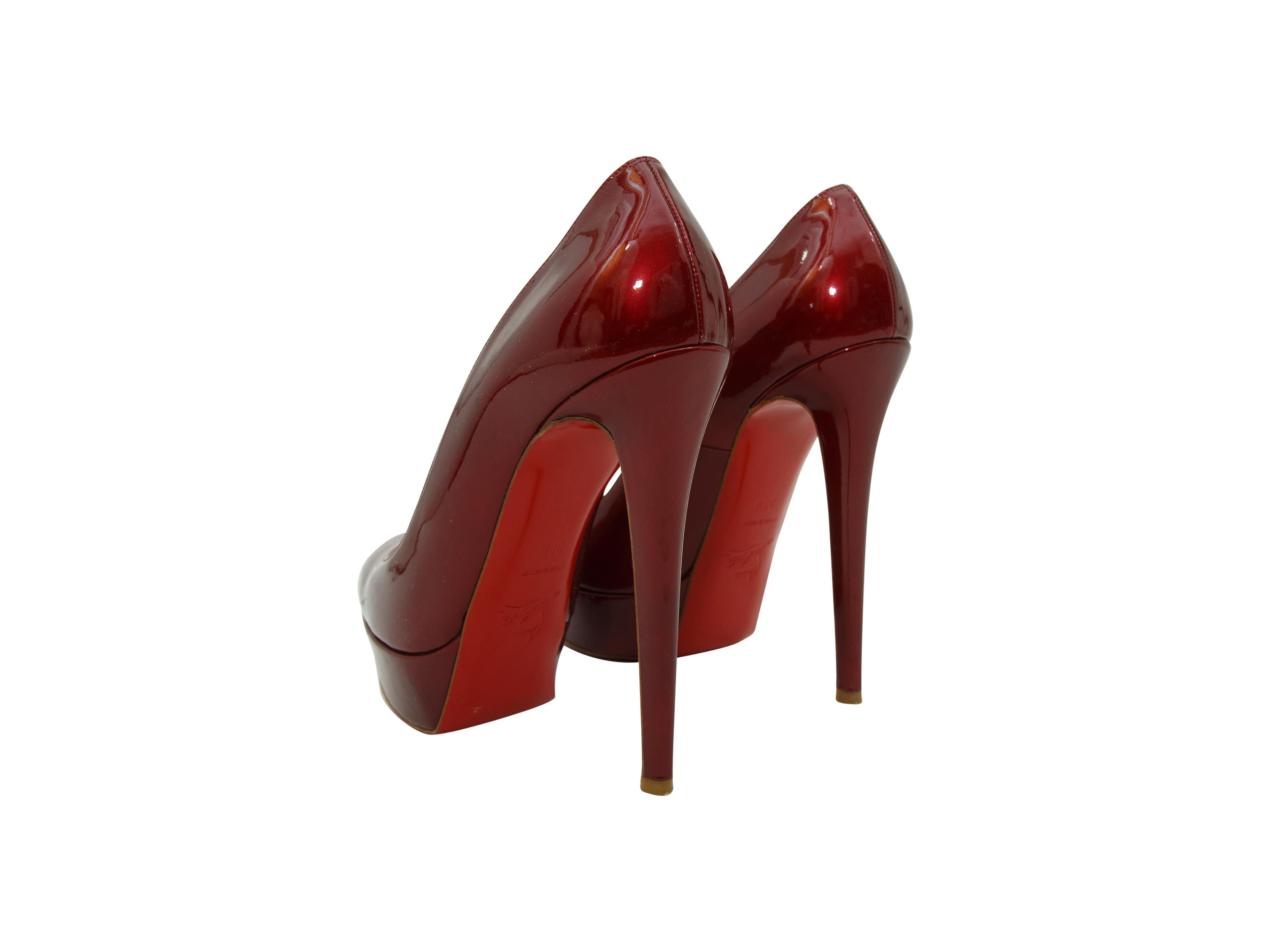 Product details:  Metallic red patent leather platform pumps by Christian Louboutin.  Round toe.  Towering stiletto and platform design.  Iconic red sole.  5.5