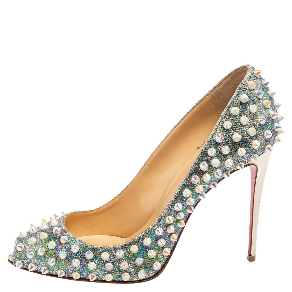 Upgrade your look by adding these Christian Louboutin Flo pumps. Covered in glitter and spike studs, the pumps are outlined with peep toes and sleek heels for a stunning silhouette.