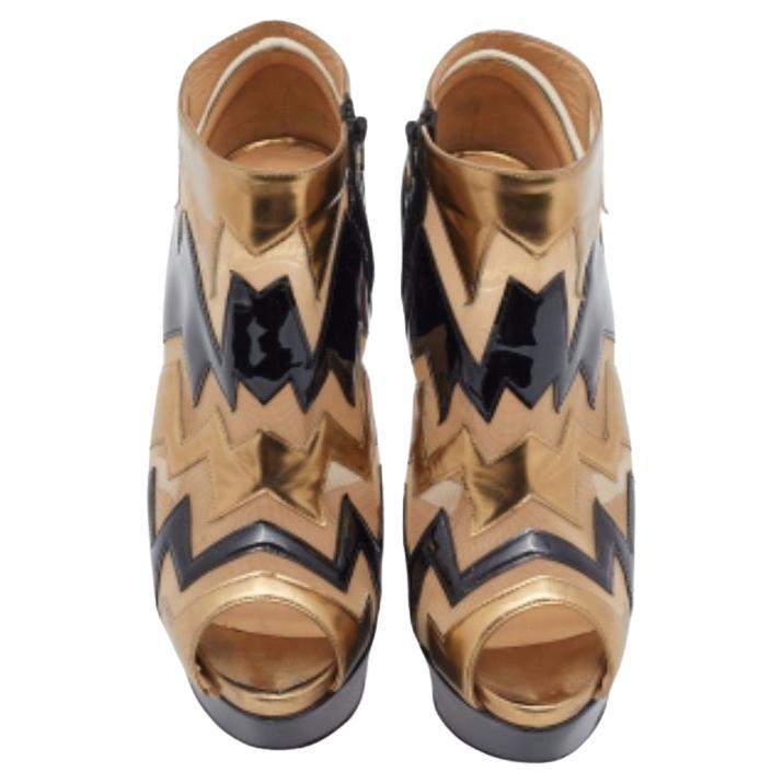 Christian Louboutin brings refinement and style to your wardrobe with these fabulous booties. Designed using multicolored patent leather and mesh, these booties are enriched with peep toes, 14.5 cm heels, and platforms. Black-tone hardware adorns