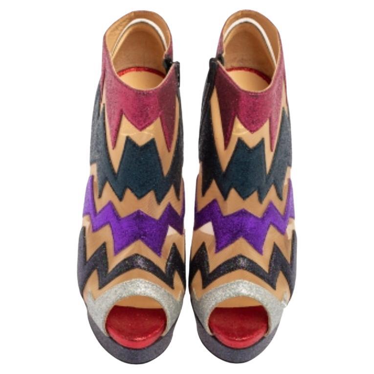 Adorn your feet with these glittering booties from Christian Louboutin. They have a mesh exterior with a zig-zag pattern and feature peep-toe, black-tone hardware, and side zippers. The leather insole and stiletto heels will ensure a comfortable