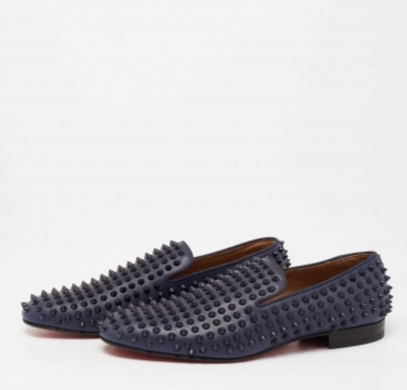 Confectionnées en cuir bleu marine, ces pantoufles de smoking Christian Louboutin sont tout simplement remarquables ! Elles présentent une silhouette à bout rond et les embellissements à pointes signature ornent l'extérieur. Elles sont dotées de