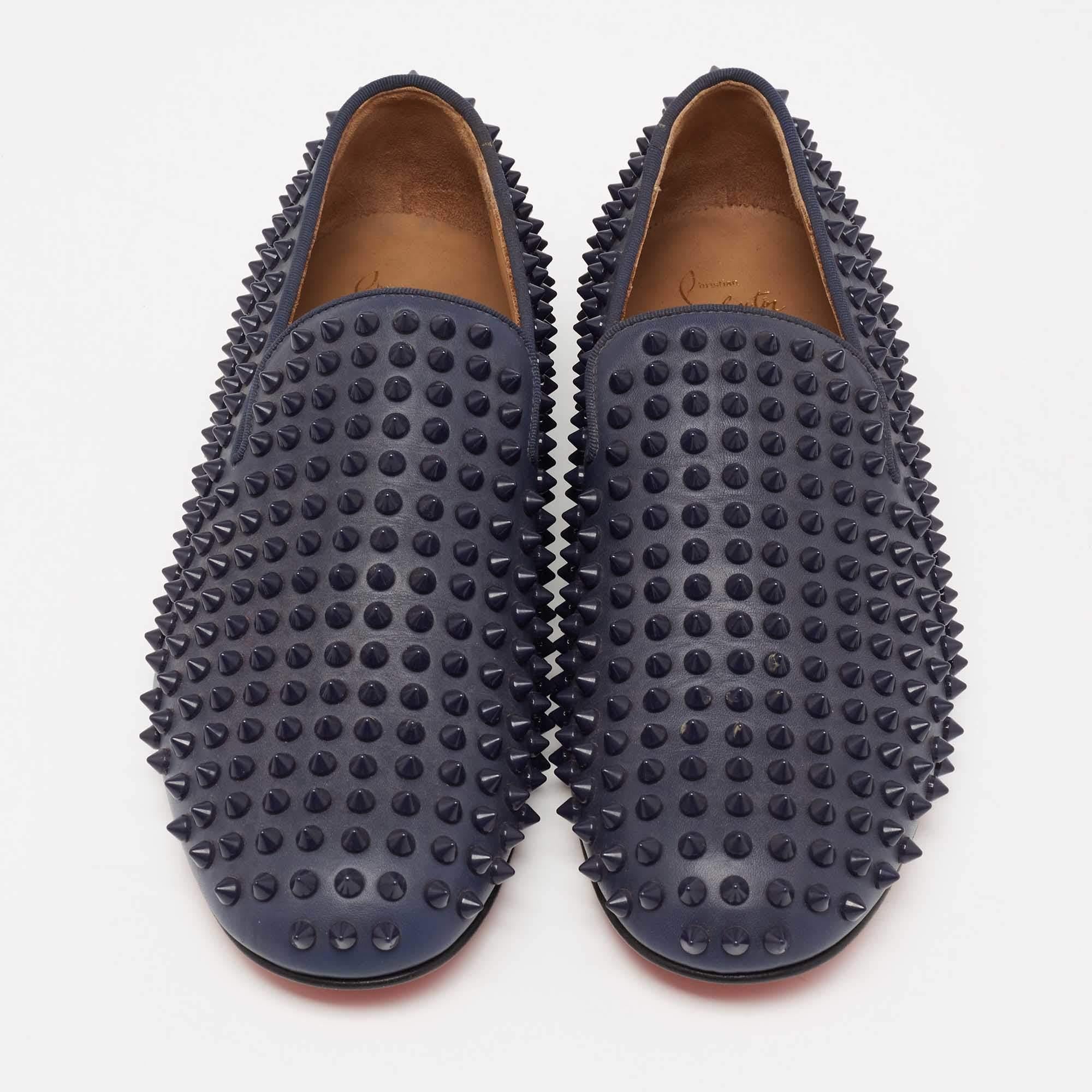 Crafted from navy blue leather, these smoking slippers from Christian Louboutin simply stand out! They feature a round-toe silhouette with the signature spike embellishments adorning the exterior. They are complete with comfortable leather-lined