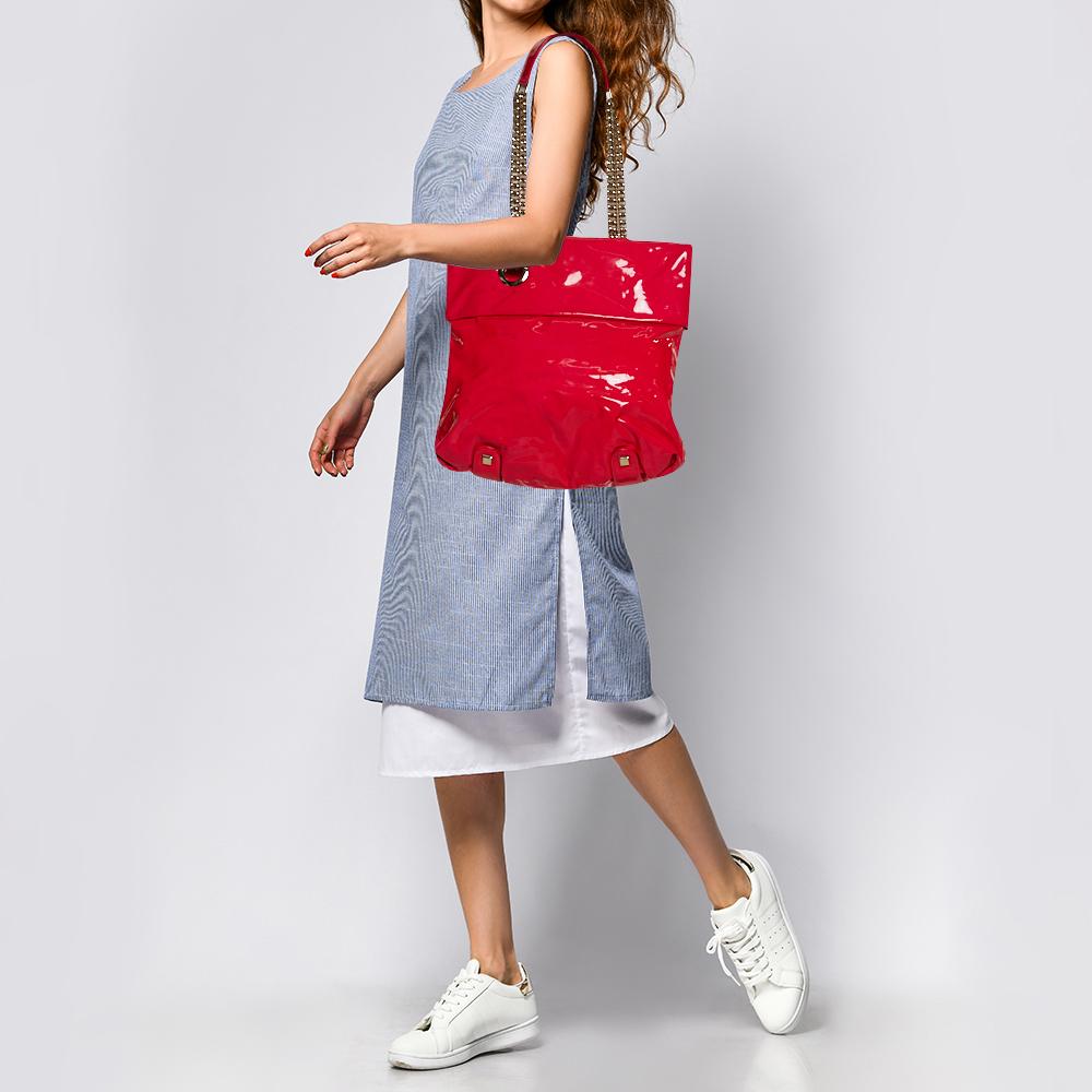 Embrace the on-going trends in style with this chic tote by Christian Louboutin that is built for everyday use. Crafted with neon pink patent leather, this bag will look sharp as ever every time you carry it. The fabric-lined interior is spacious