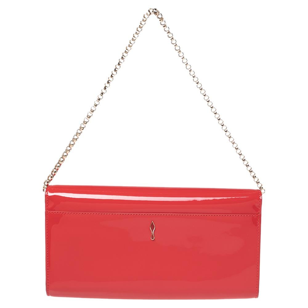 Crafted from patent leather and covered in a neon red hue, this Christian Louboutin clutch has a style that will catch glances from a mile. It is designed with a flap that reveals a suede interior and it is held by a chain. The fashionable logo on