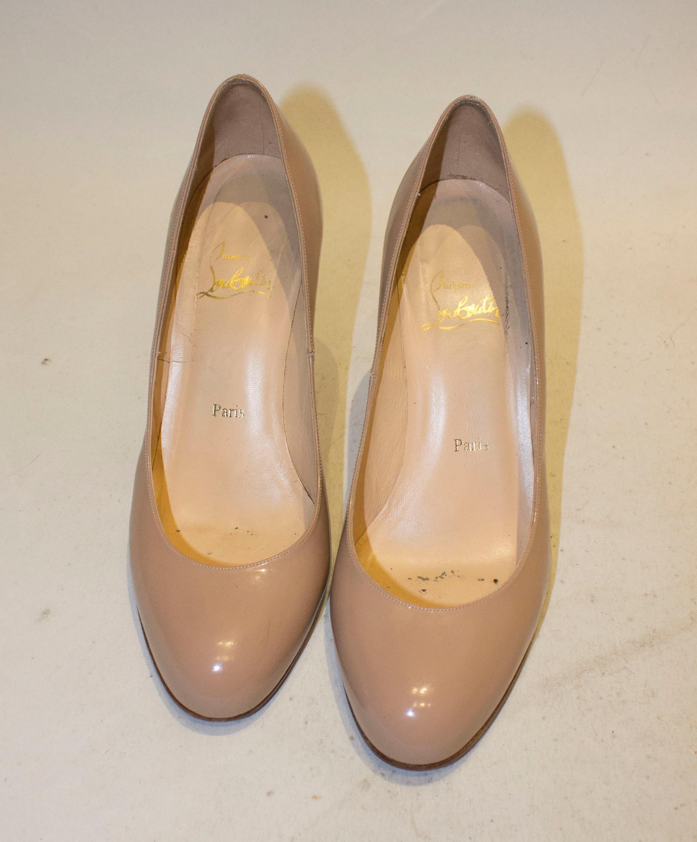 A chic pair of nude patent heels by Christian Louboutin. The nude heels have an almond toe, leather sole and a marked a size 38 1/2 , heel height 3 1/2 ''