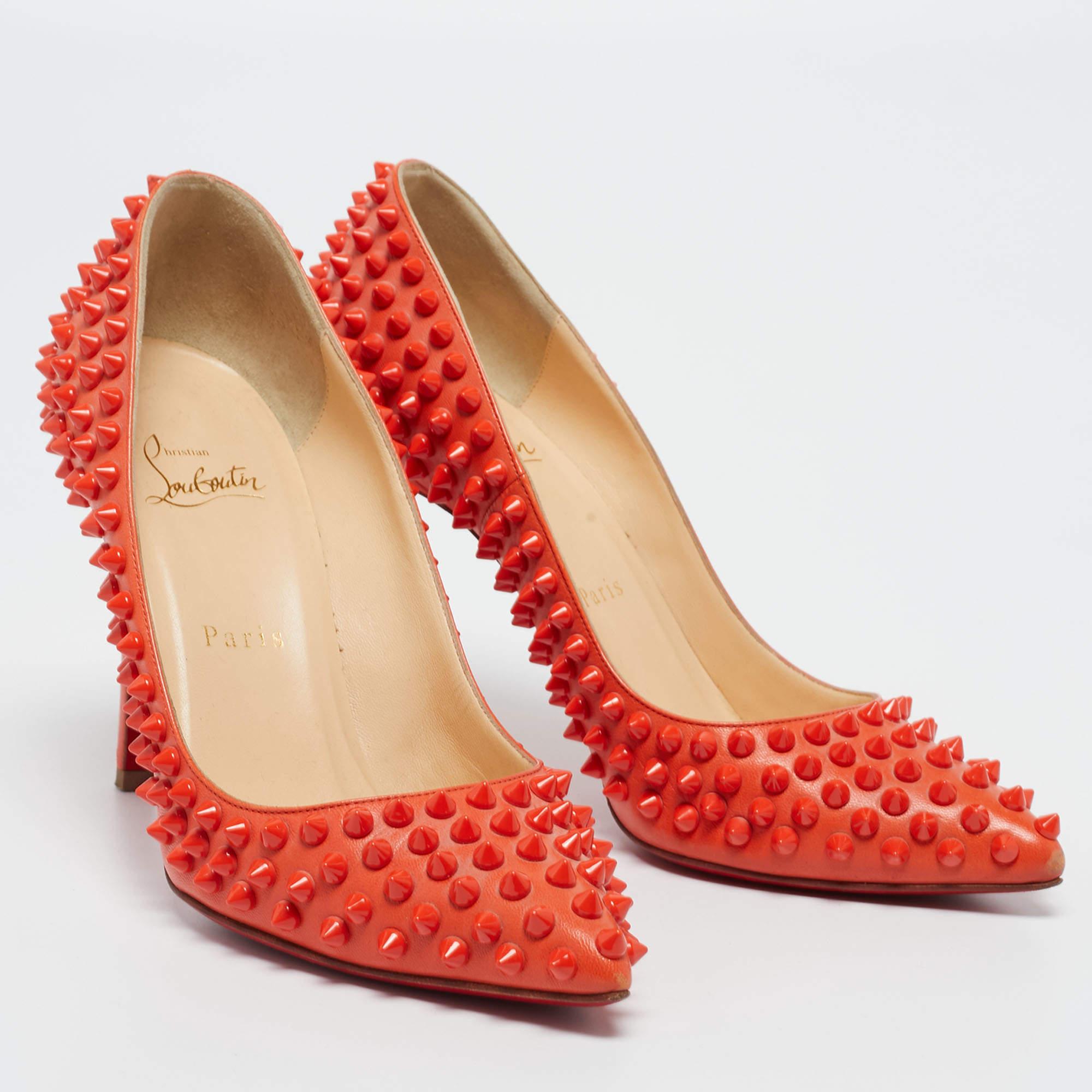 Dazzle everyone with these Louboutins! Crafted from leather, these orange pumps have pointed toes, multiple spikes adorning the exterior, and 10 cm heels. Complete with the signature red soles, this pair embodies the fine art of shoemaking.

