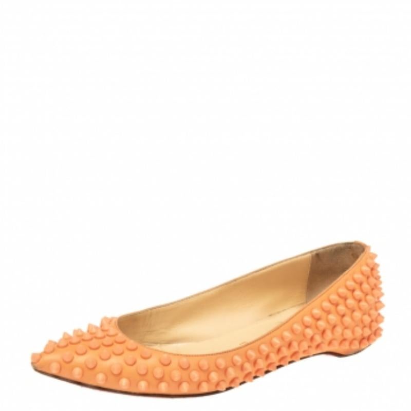 Die Schuhe von Christian Louboutin zeichnen sich durch eine zeitgenössische Kühnheit aus, die unbestreitbar den Geist der modernen, modebegeisterten Frau trifft. Die aus Leder gefertigten Ballerinas sind außen mit orangefarbenen Spikes verziert. Die