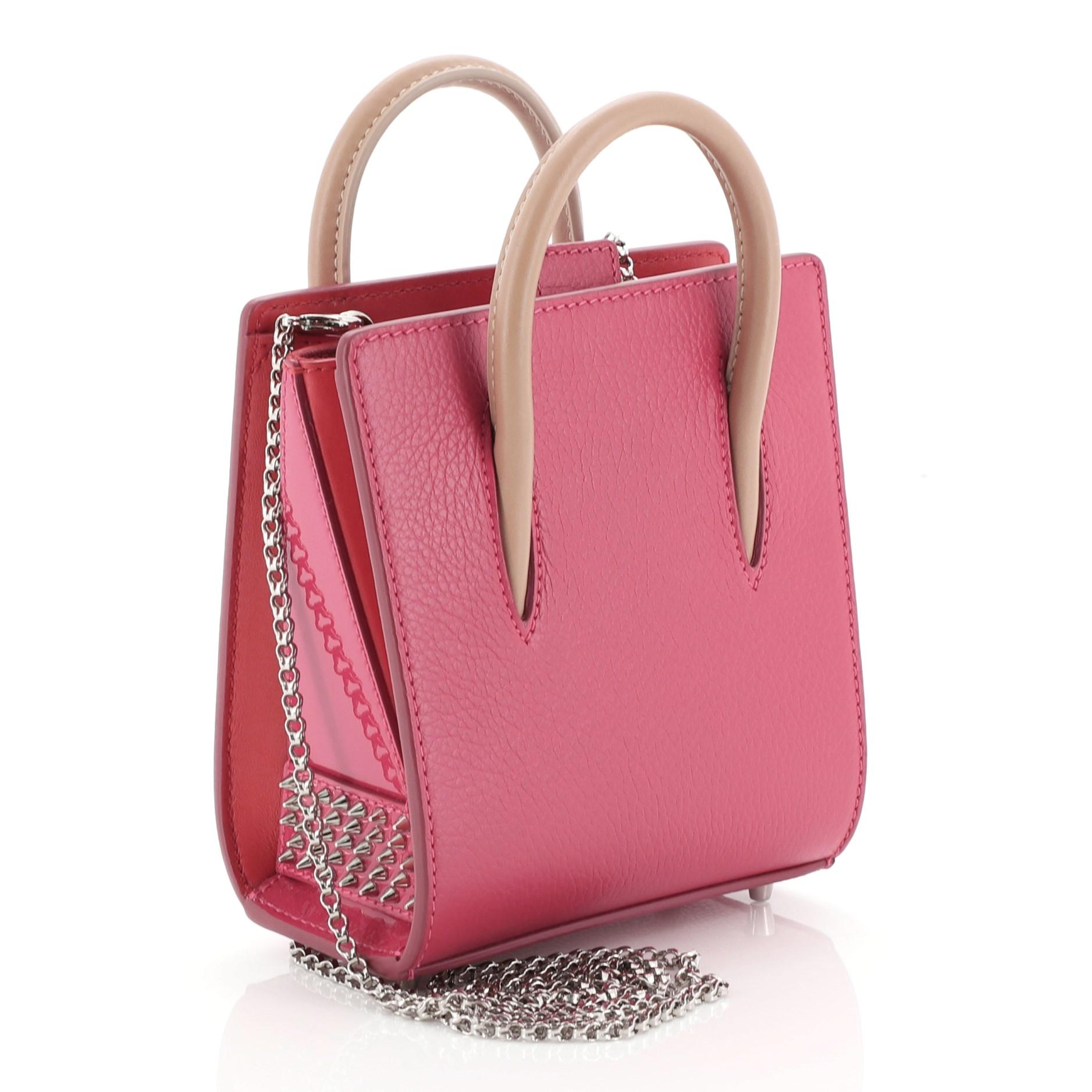 This Christian Louboutin Paloma Tote Leather Nano, crafted in red and pink leather, features spiked leopard print on the sides, dual-rolled leather handles, and silver-tone hardware. It opens to a red microfiber interior with zip pocket. 

Estimated