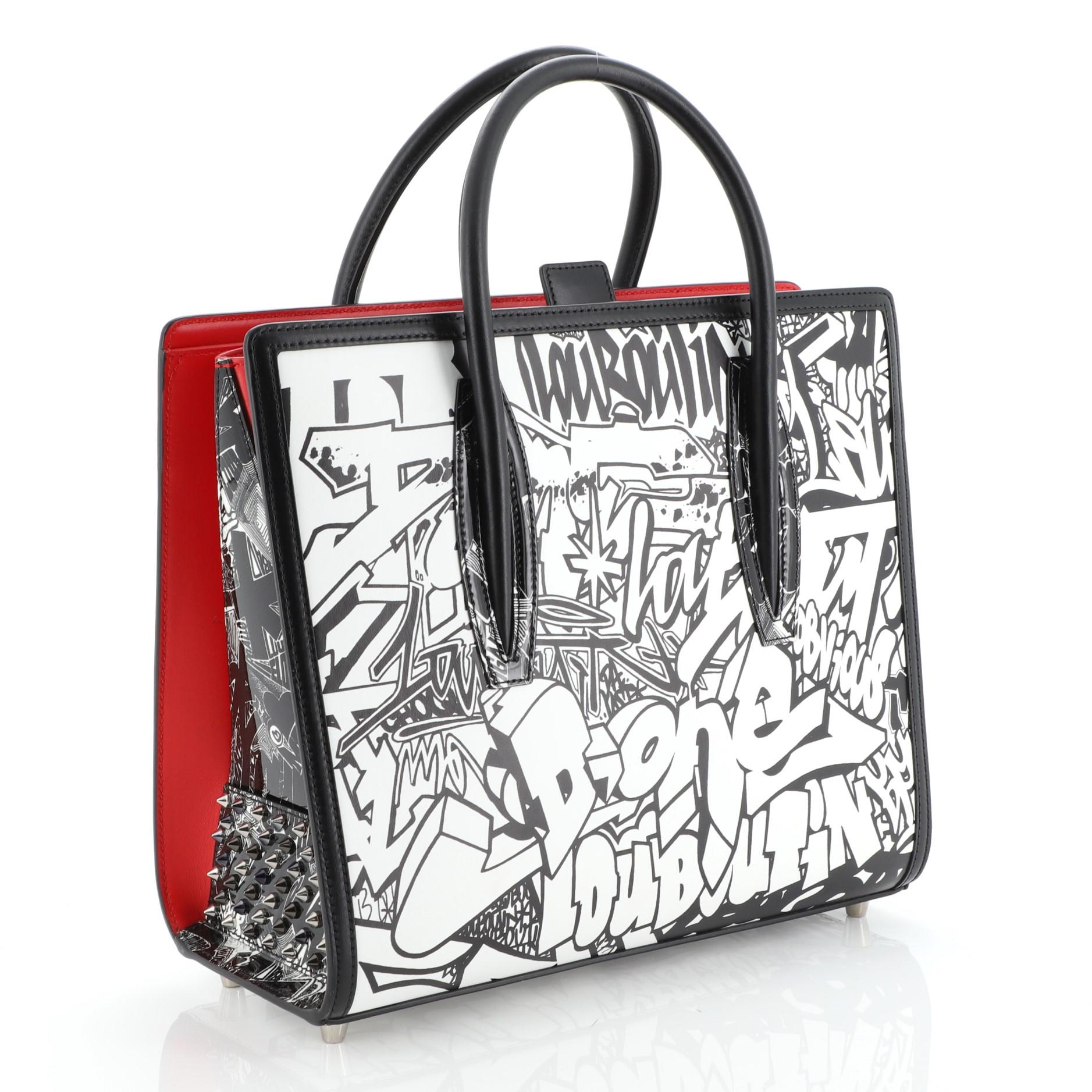 This Christian Louboutin Paloma Tote Printed Leather Medium, crafted in black and white printed leather, features dual rolled leather handles, spiked leather on the sides, protective base studs, and silver-tone hardware. Its tab closure opens to a