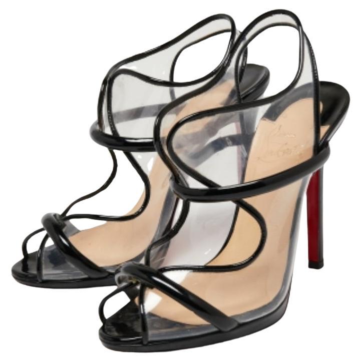 Bold and chic, these Christian Louboutin sandals define a modern woman in every detail. They are constructed from patent leather and PVC with artistic cuts on the upper and their signature red-lacquered soles will add grace to your every step.