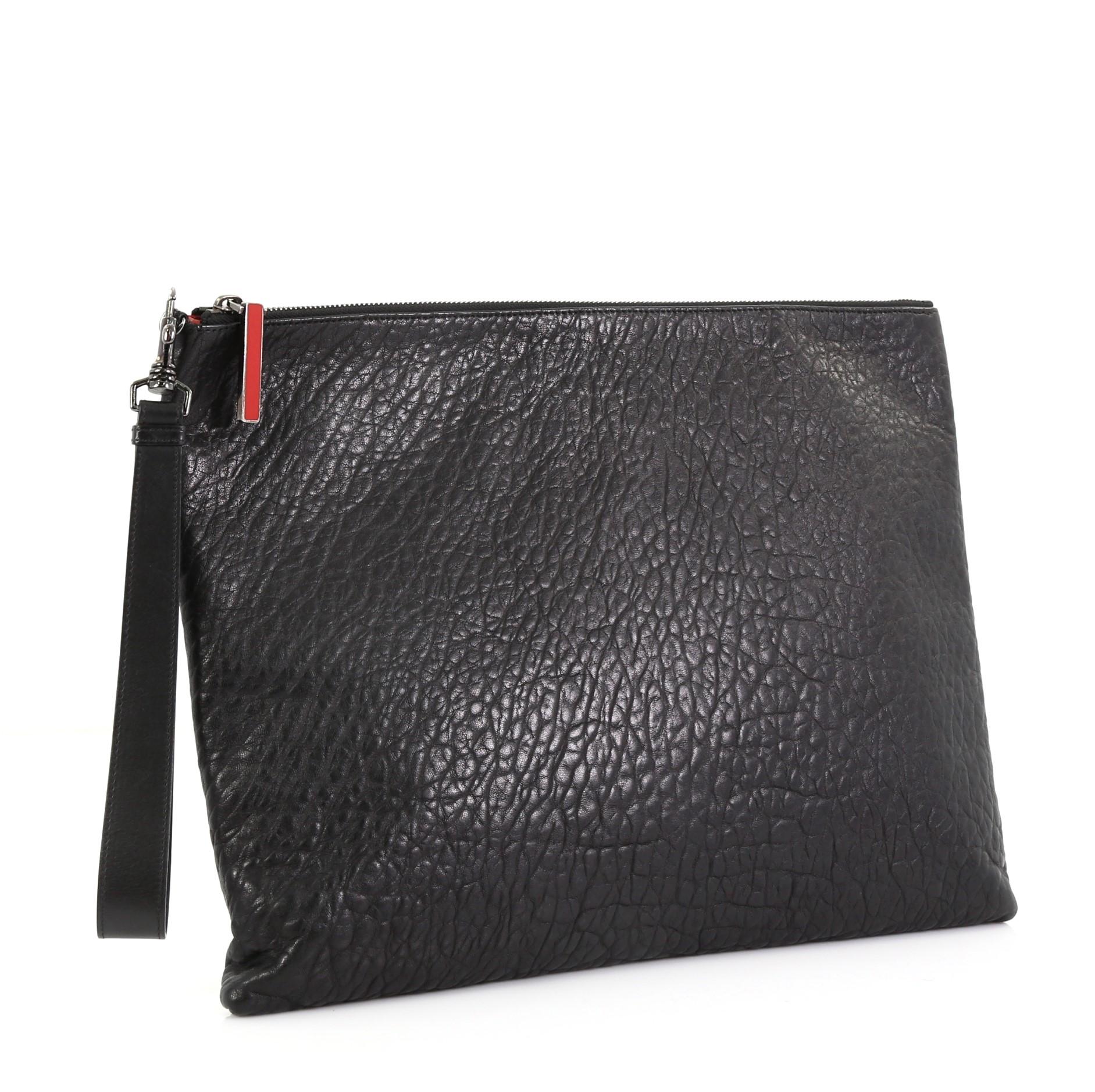 This Christian Louboutin Peter Pouch Leather Medium, crafted from black leather, features a wristlet strap, exterior back zip pocket, and aged silver-tone hardware. Its zip closure opens to a red fabric and leather interior with multiple card slots