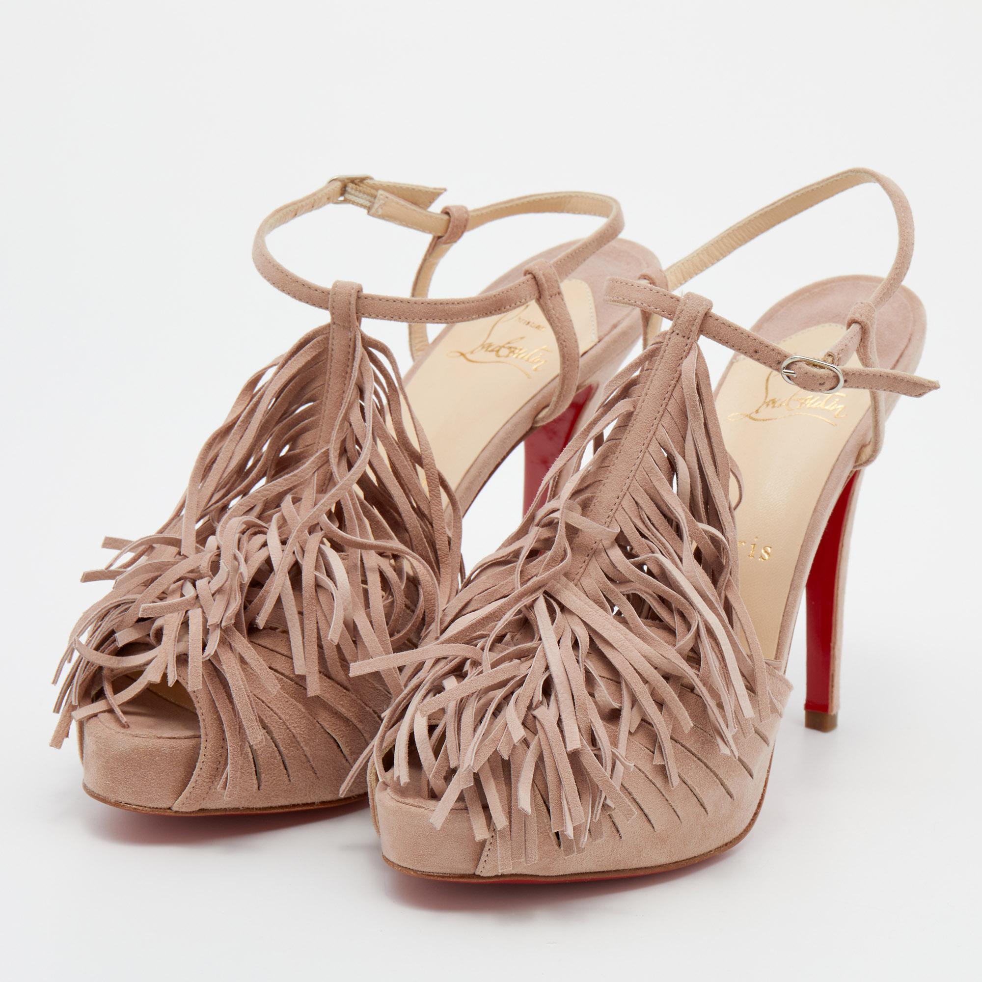 Christian Louboutin teaches us how to make a statement with these gorgeous T-strap sandals. Created using pink suede, the attractive shoes are enhanced with fringes on the uppers, sturdy platforms, and 12 cm heels.


