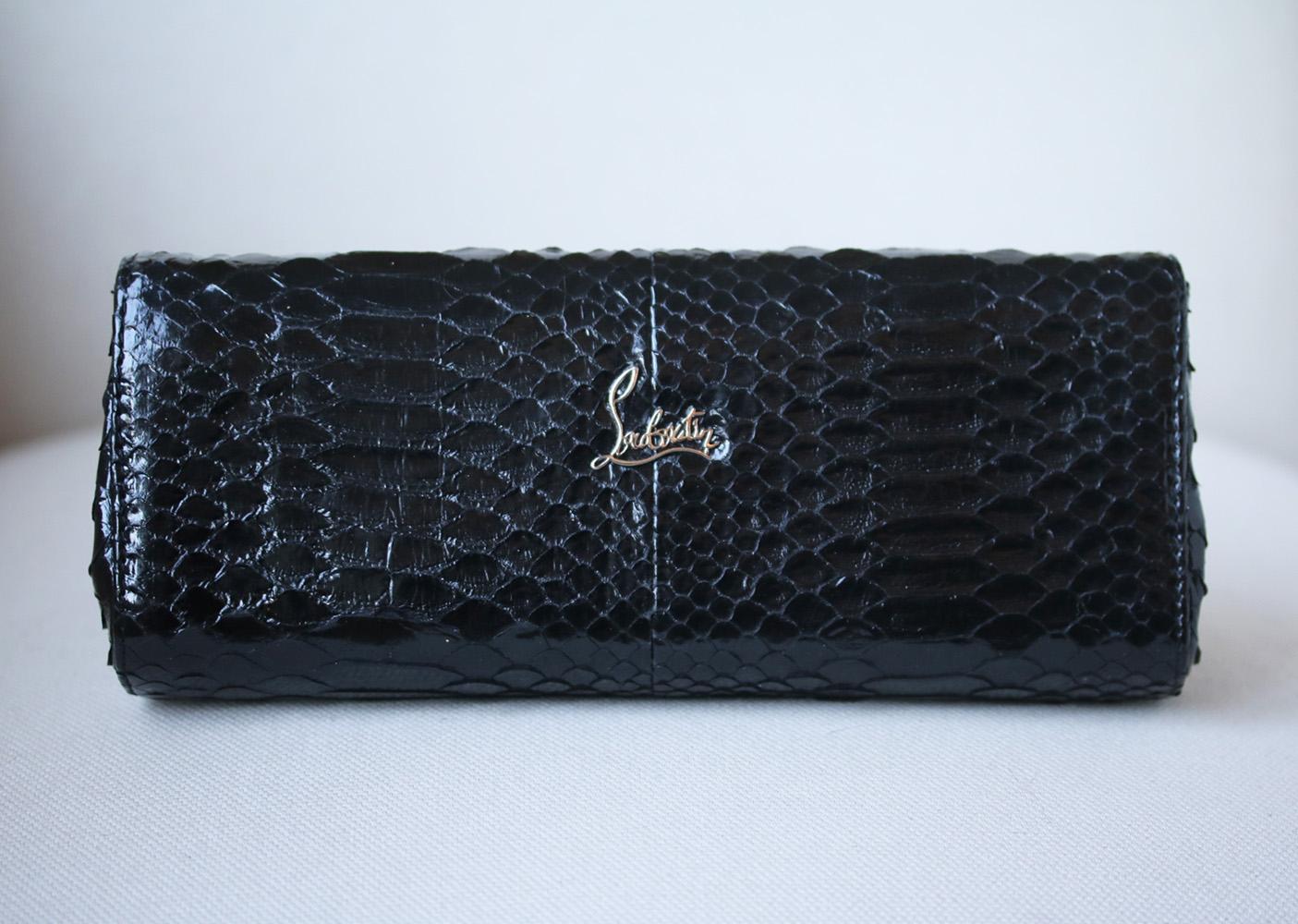 Christian Louboutin's clutch is crafted in Italy from black python and smooth leather. This spacious design has two internal compartments and a pull-out mirror for touching up your lipstick. Black python and leather (Calf). Two snap-fastening front