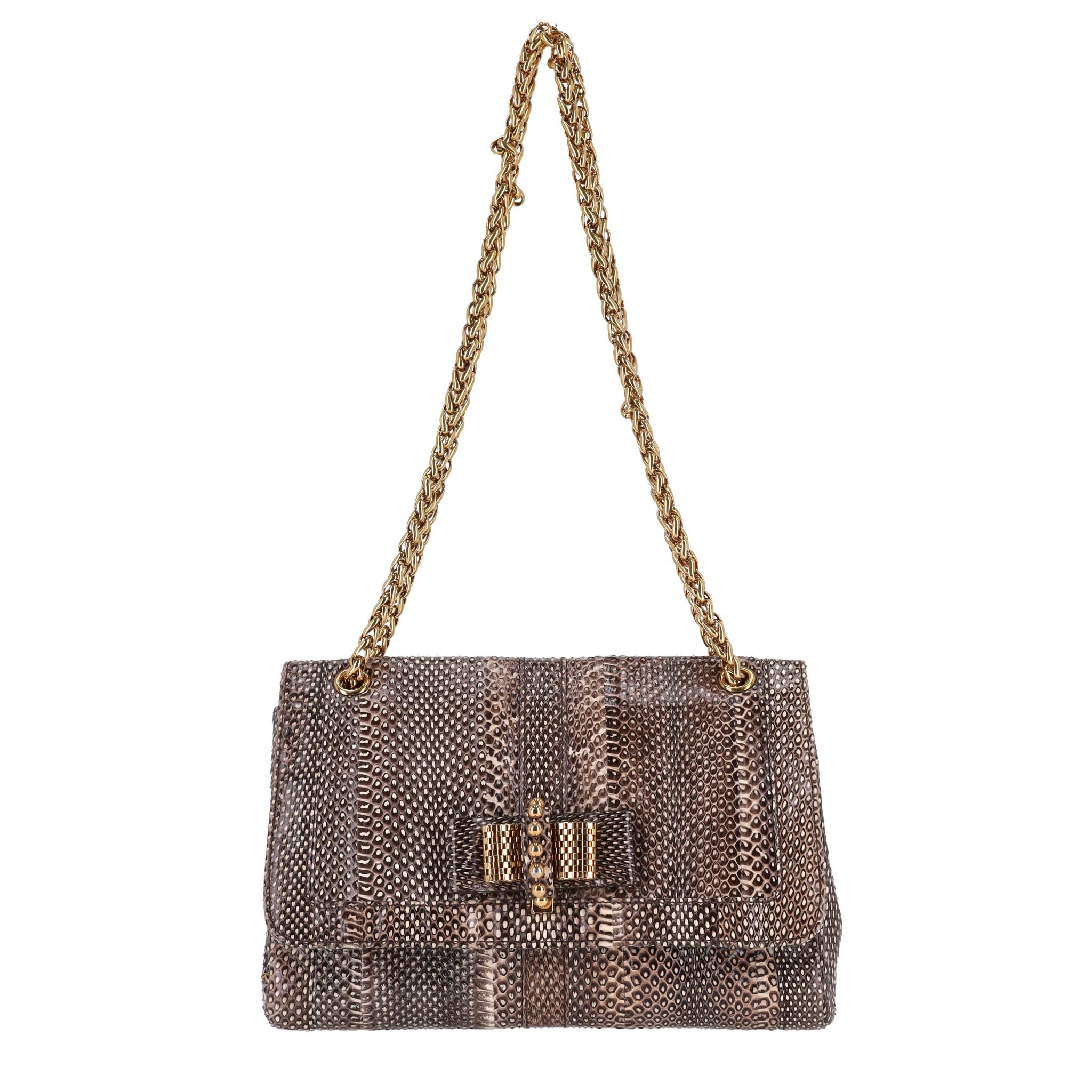Christian Louboutin Python Skin Sweet Charity Bag

Beige and brown tone bag crafted from exotic snake skin.

Gold chain shoulder strap and bow push lock closure embellishment.

'Louboutin' gold signature to the side and iconic bright red