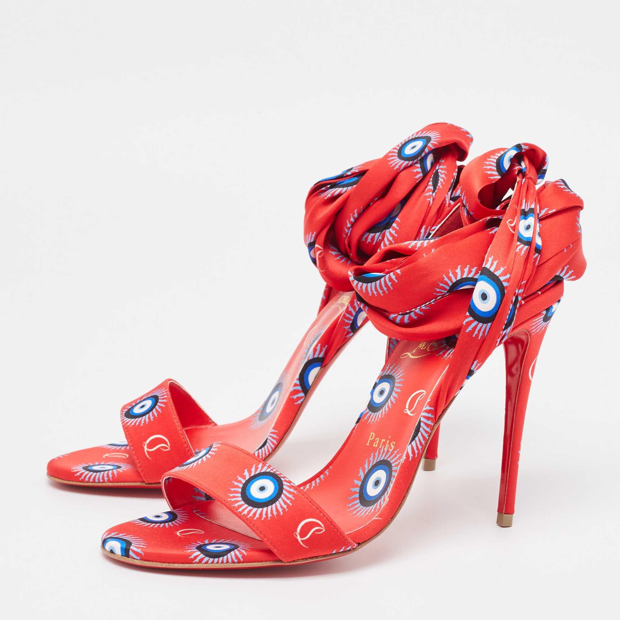 Christian Louboutin's Du Desert sandals mesmerize with vivid hues and unique evil eye detailing. Crafted from luxurious satin, these ankle-tie sandals boast iconic red soles, blending artistic flair with Parisian chic for a stunning statement.