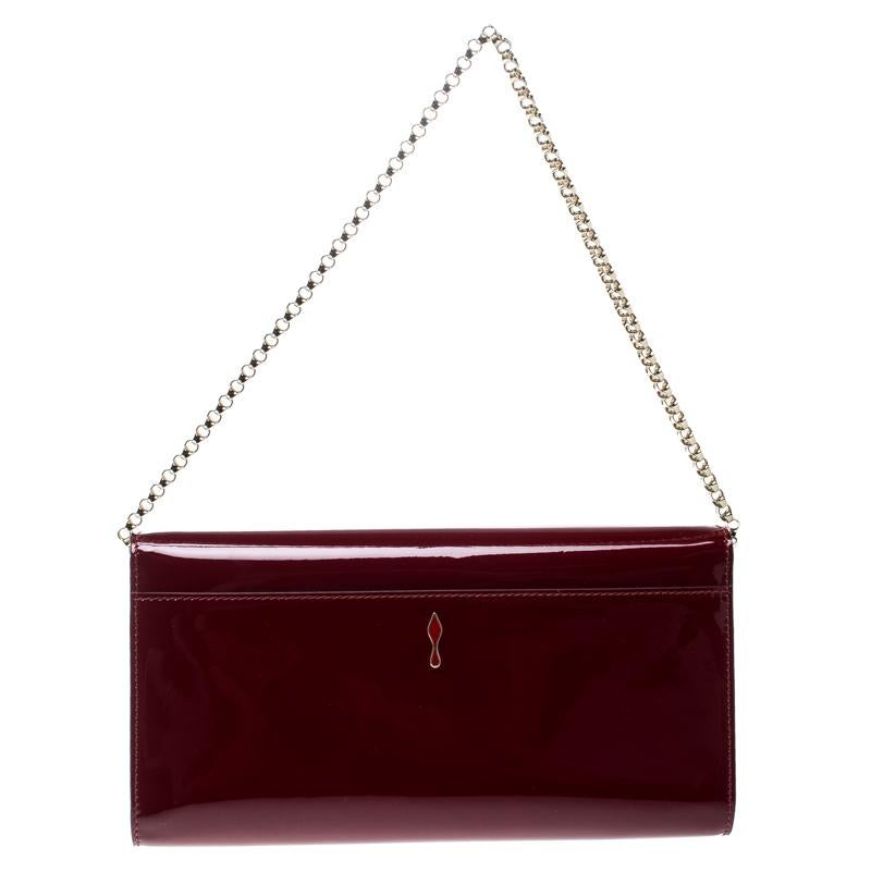 Meet the Christian Louboutin Vero Dodat Clutch! Crafted from rich red patent leather, this flap clutch features a stylish gold-tone chain strap, a brand detailed plaque at the front and a structured silhouette. The flap snap enclosed interior is