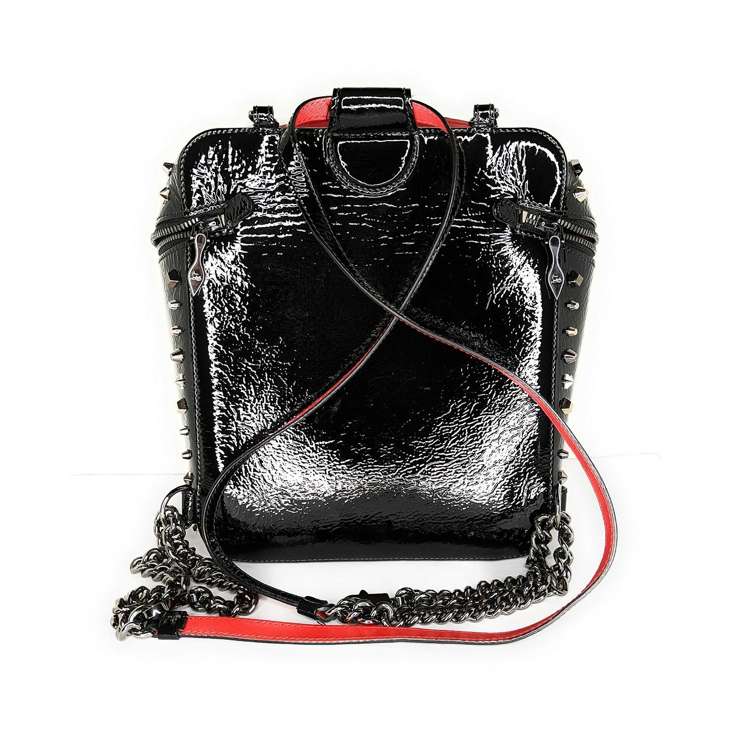 Spiky studs and a polished logo charm enhance the iconic look of a luxe backpack crafted from glossy patent leather and featuring a Louboutin-red interior. The structured silhouette with flat base prevents the bag from tipping over when you put it