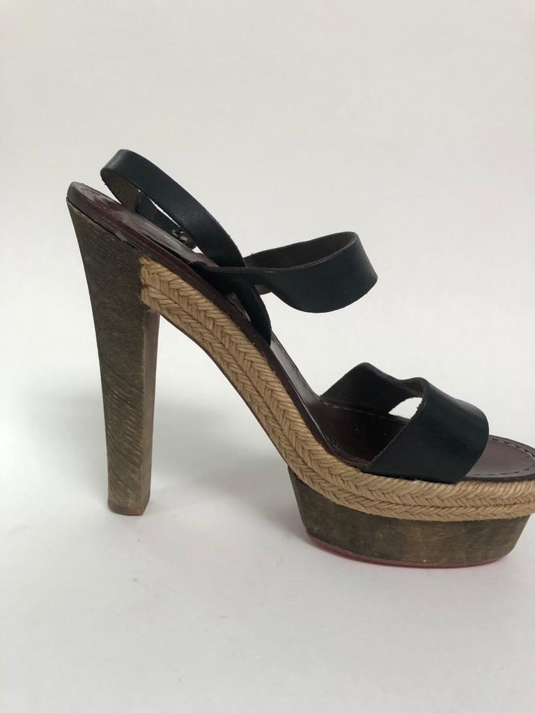 These are cool girl sandals, Thick black leather straps pair with stacked wood heel and woven trim.