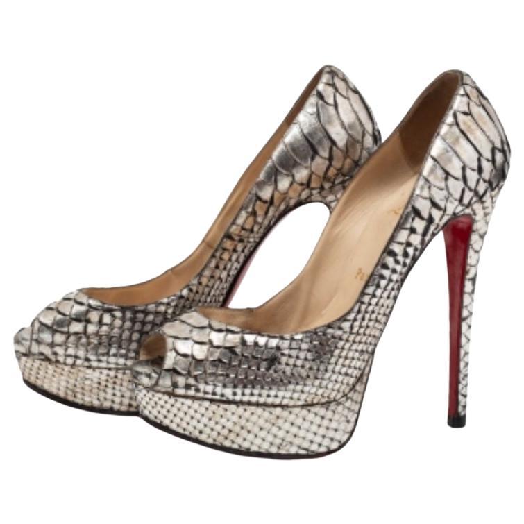 Heben Sie sich von der Masse ab mit diesem Paar  Christian Louboutin-Pumps, die High Fashion mit Klasse ausstrahlen. Dieses Modell aus Pythonleder ist eine Kreation aus der Lady Peep Collection'S. Er hat einen silberfarbenen Metallic-Ton, eine