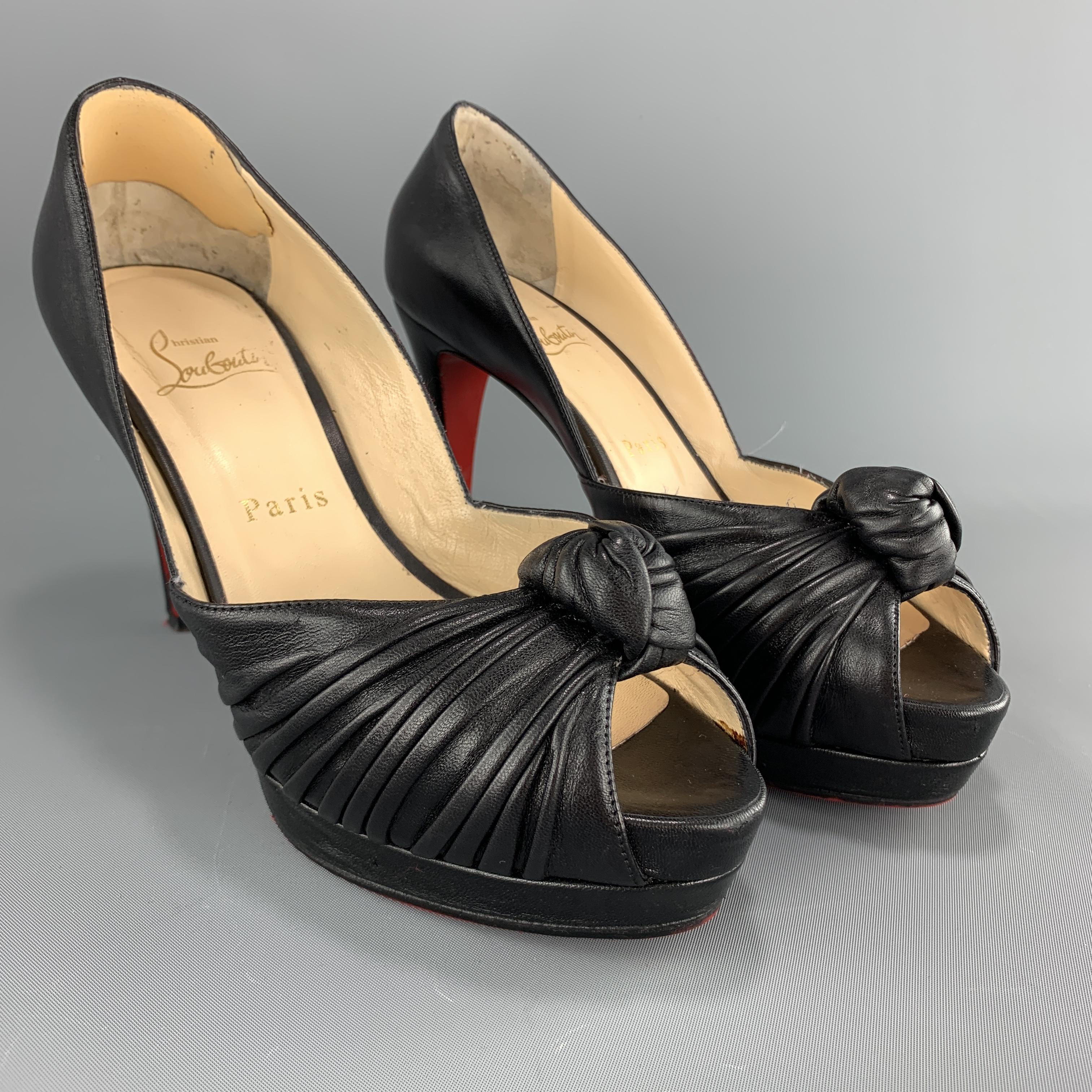 CHRISTIAN LOUBOUTIN pumps come in black leather with a knotted peep toe strap and platform. Made in Italy.

Very Good Pre-Owned Condition.
Marked: IT 37

Measurements:

Heel: 3.75 in.
Platform: 1.25 in.