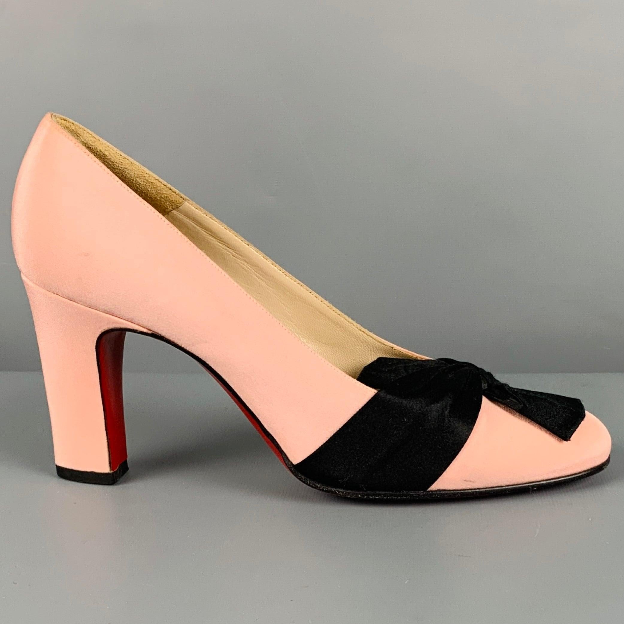 CHRISTIAN LOUBOUTIN pumps
in a
pink fabric featuring iconic red sole, and black bow detail. Comes with dust bag. Made in Italy.Good Pre-Owned Condition. Moderate signs of wear, please check photos. As is. 

Marked:   37.5 

Measurements: 
  Heel: