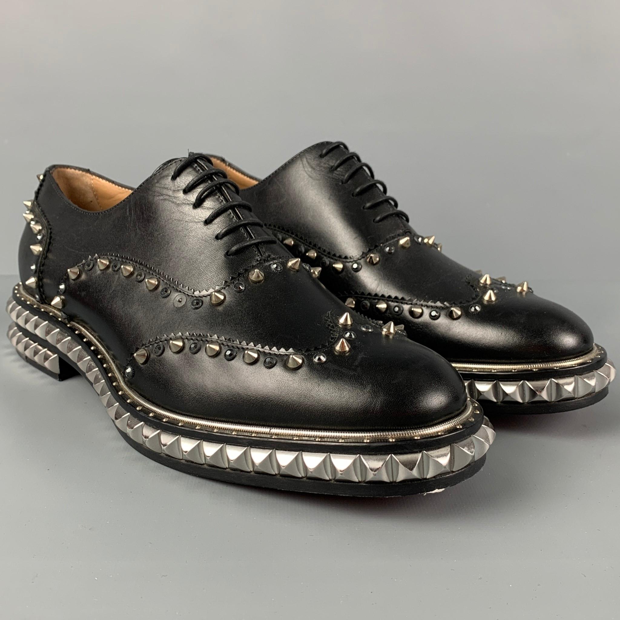 CHRISTINA LOUBOUTIN shoes comes in a black leather featuring studded details, wingtip style, signature red sole, and a lace up closure. Made in Italy. 

Very Good Pre-Owned Condition.  Minor wear, missing a stud.
Marked: 41

Outsole: 12 in. x 4 in. 