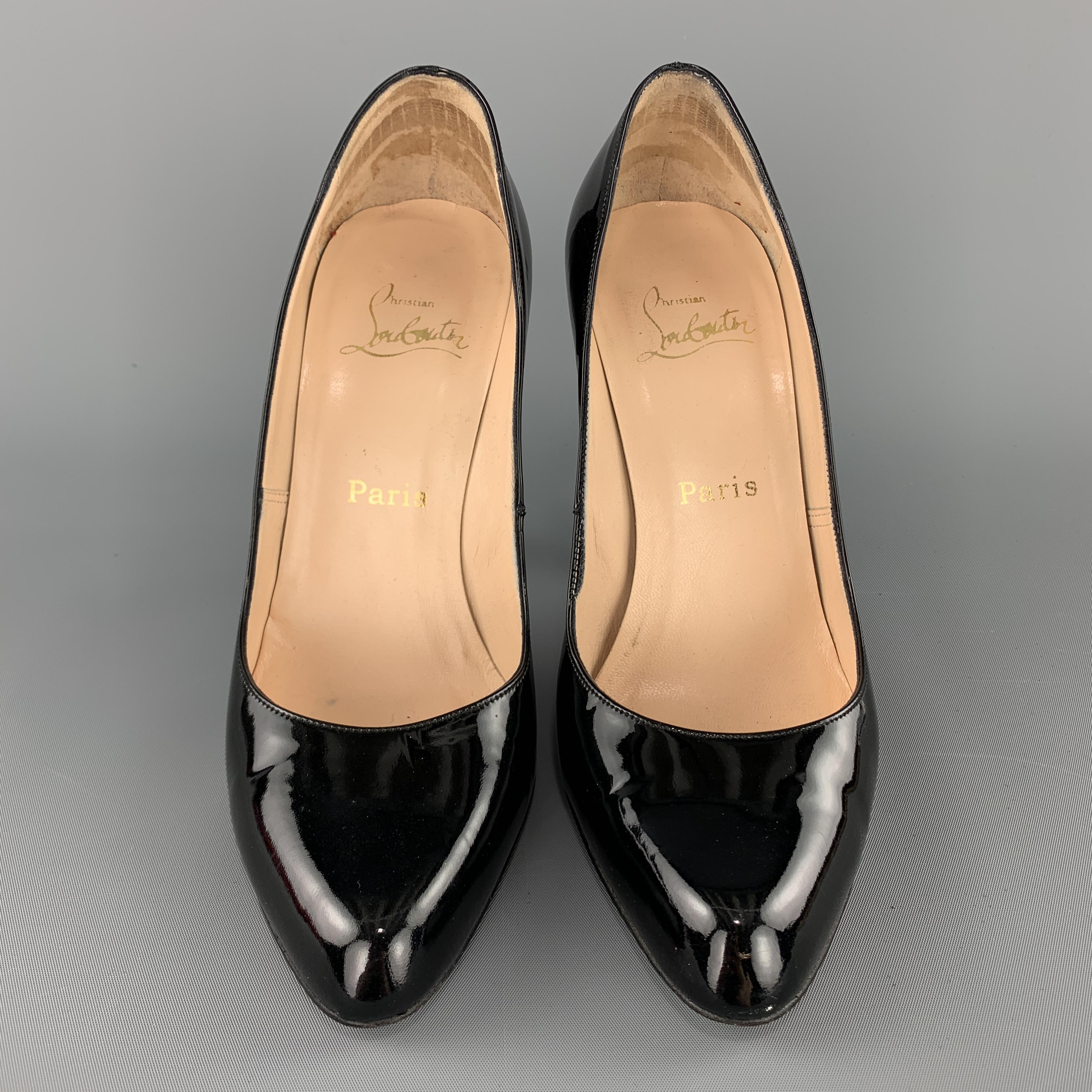 CHRISTIAN LOUBOUTIN classic pumps come in glossy patent leather with a subtle pointed toe and covered stiletto heel. Made in Italy.

Very Good Pre-Owned Condition.
Marked: IT 38.5

Heel: 4.45 in.