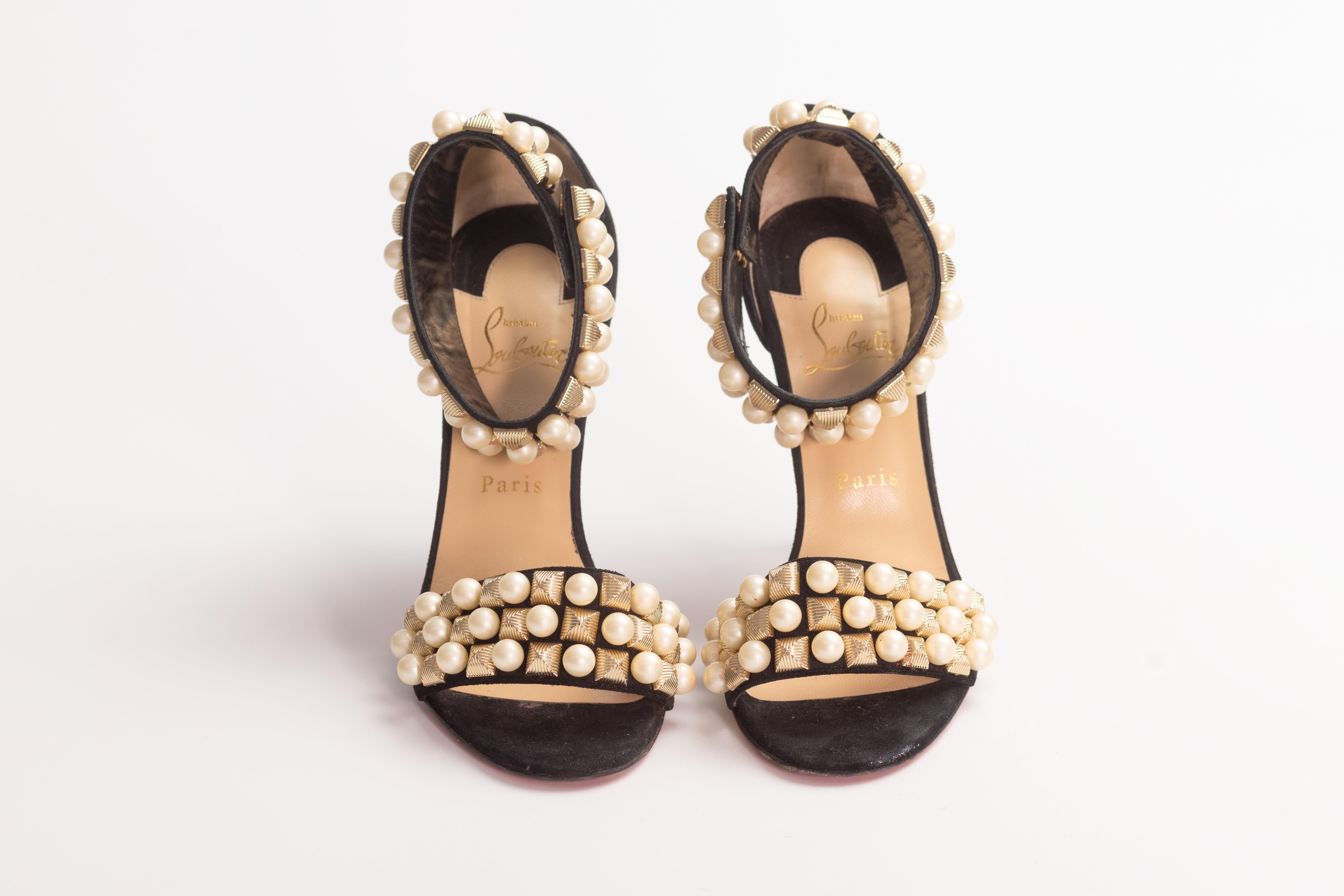 CHRISTIAN LOUBOUTIN STUDS PEARLS BLACK VELVET TUDOR HEELS (EU 39)

These Christian Louboutin sandals are made from black suede. They feature almond open toes, straps at the vamps, ankle straps with snap button closure, gold tone studs and round