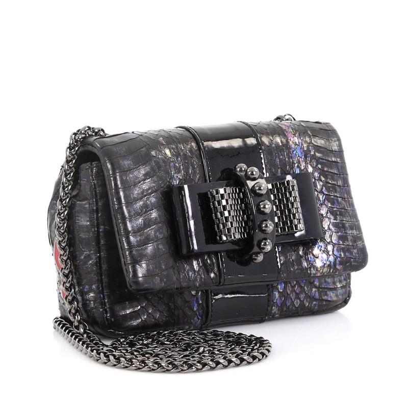 This Christian Louboutin Sweet Charity Crossbody Bag Python Mini, crafted from genuine iridescent python, features a long chain strap, Louboutin red sole decor, mesh bow design, and gunmetal-tone hardware. Its hidden magnetic snap closure opens to a