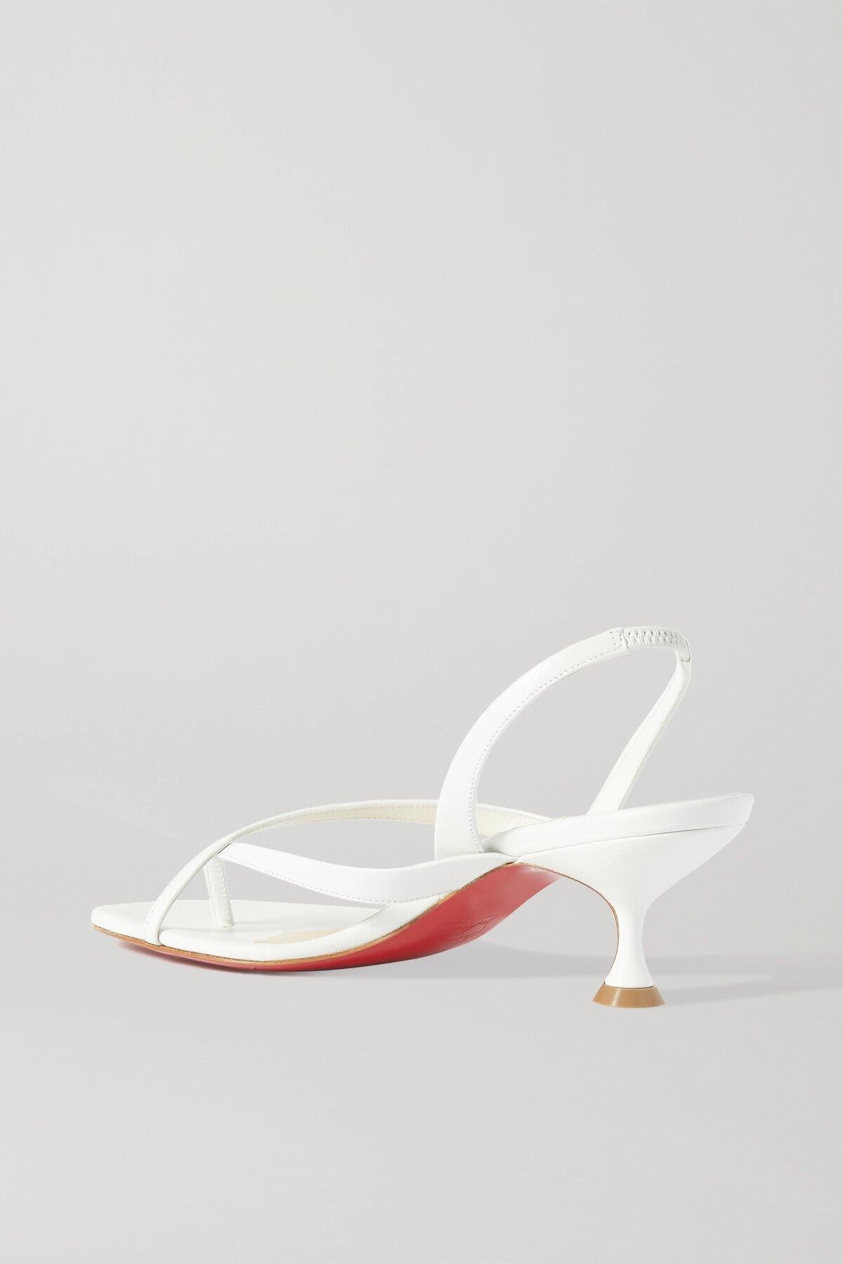 Christian Louboutin's retro 'Taralita' sandals have been made in Italy from soft strips of leather that elegantly cross at the front. They're set on a slightly flared kitten heel and lacquered in the iconic red hue at the glossy soles. The slingback