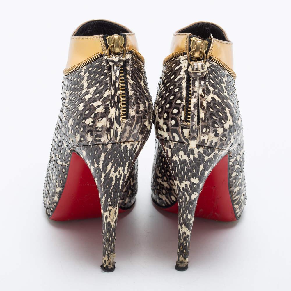Christian Louboutin is all set to impress you with this stunning pair of ankle booties. Crafted from snakeskin and leather, they feature zipper details, slender heels, and gold-tone hardware. The insoles carry brand labeling. This pair of booties